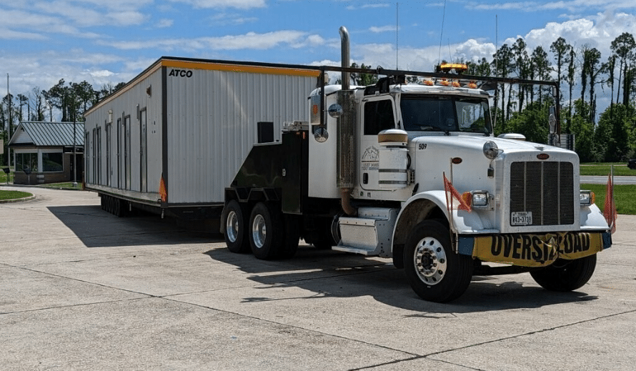 White Toter Truck with House At The Back with Willda Beast Logo on the Side